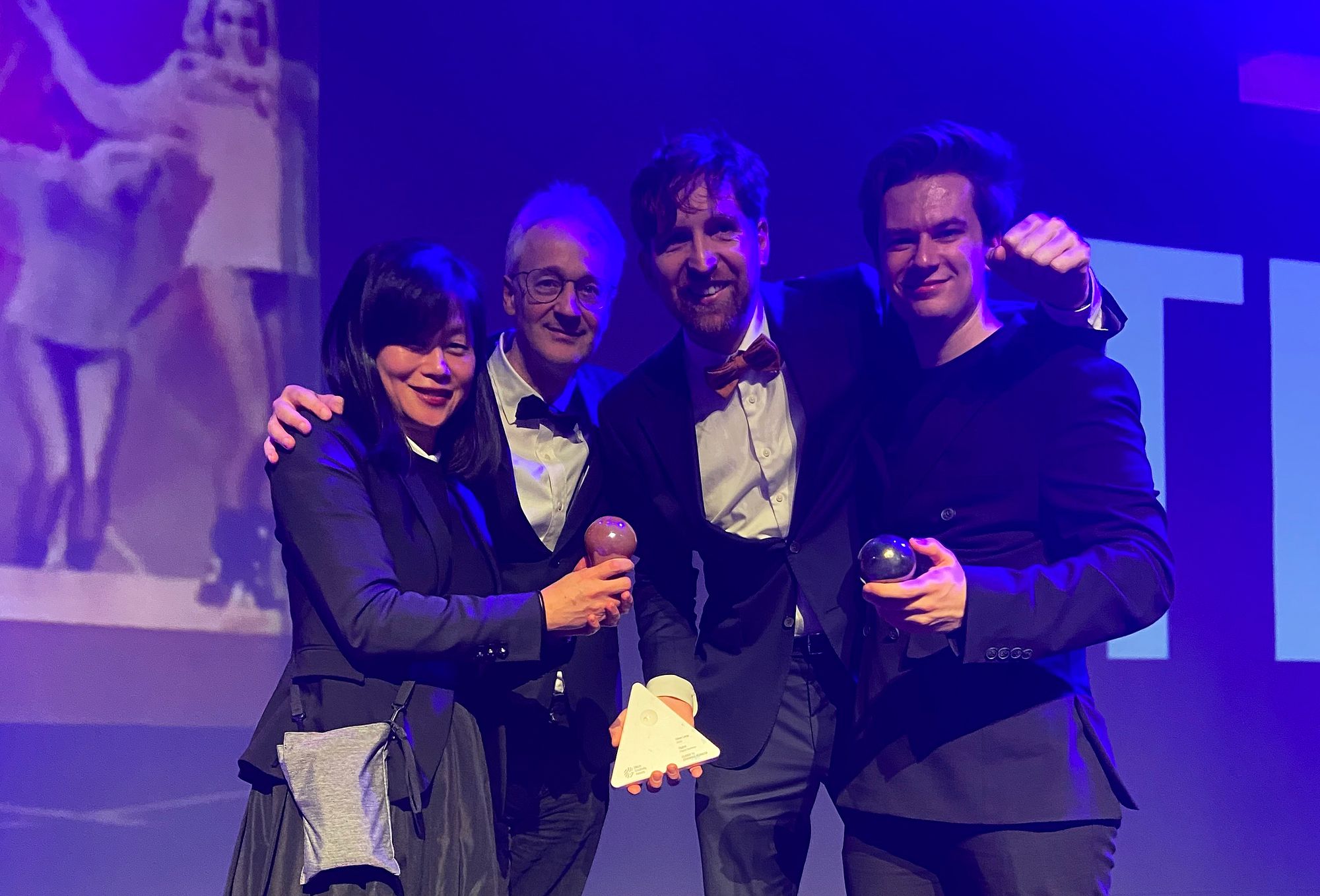 Four people on stage during an awards ceremony.